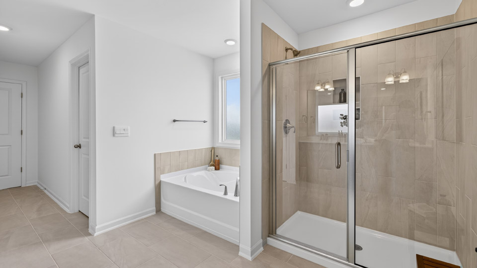 primary bathroom with walk in shower, bathtub, and dual vanity sinks