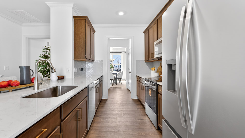 kitchen with quartz counters, kitchen peninsula, pantry, stainless steel appliances