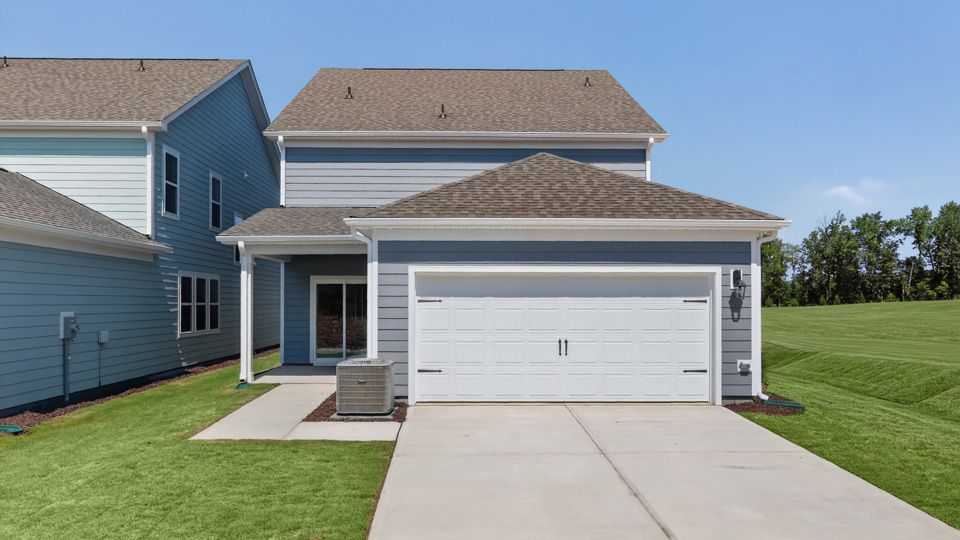 back of home with covered patio and two car garage