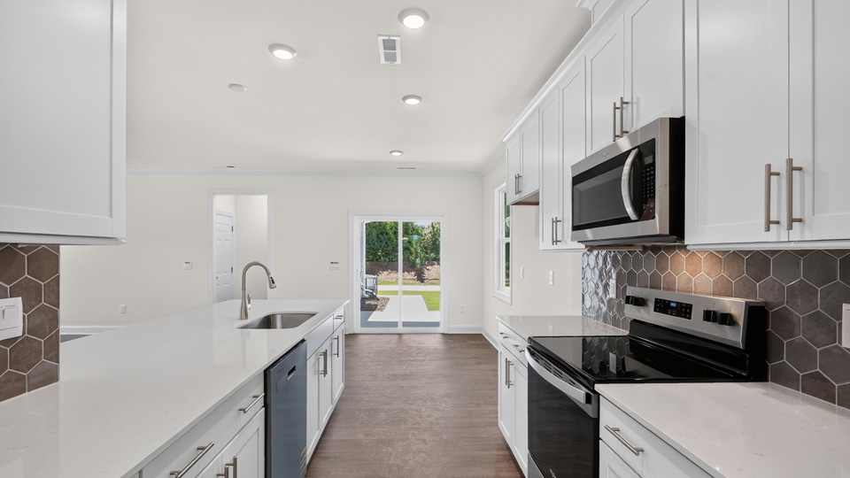kitchen with white cabinets tile backsplash and quartz countertops
