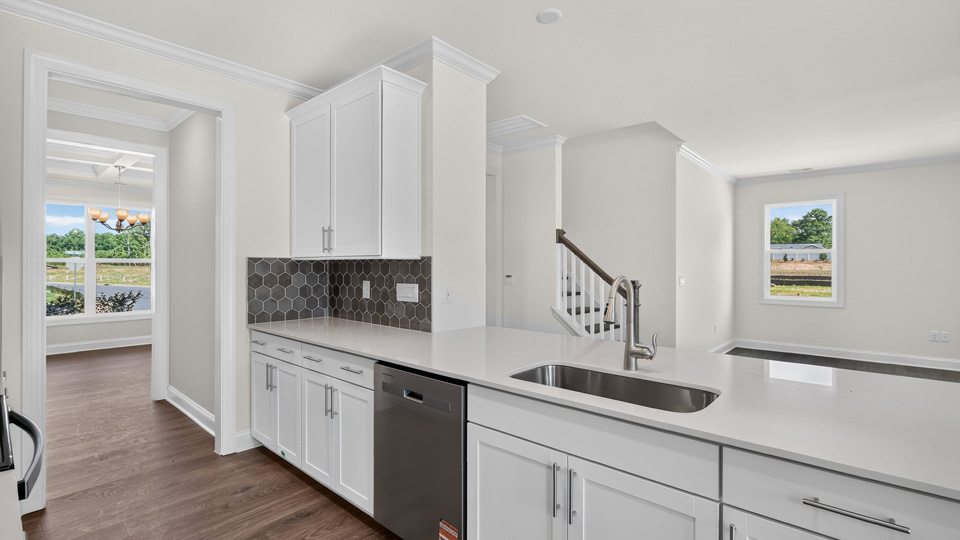 kitchen with white cabinets tile backsplash and quartz countertops