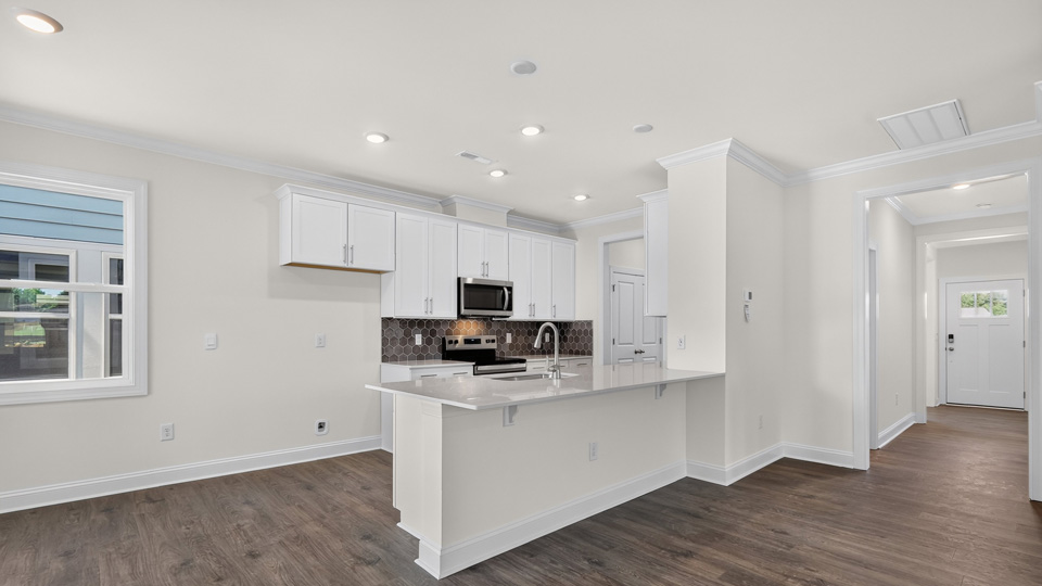 kitchen with white cabinets tile backsplash and quartz countertops