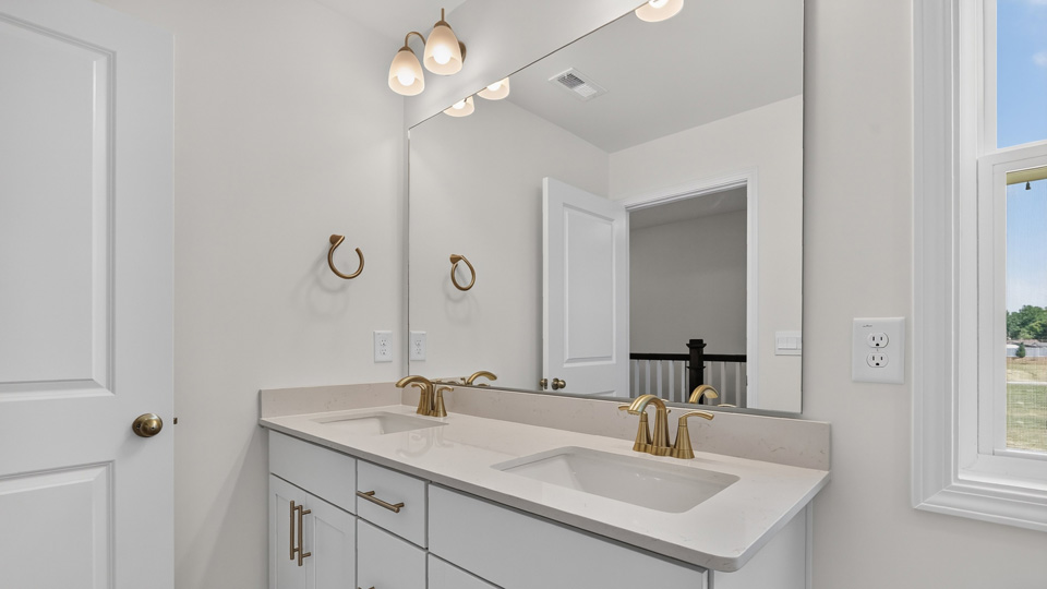 bathroom with quartz countertops and white cabinets