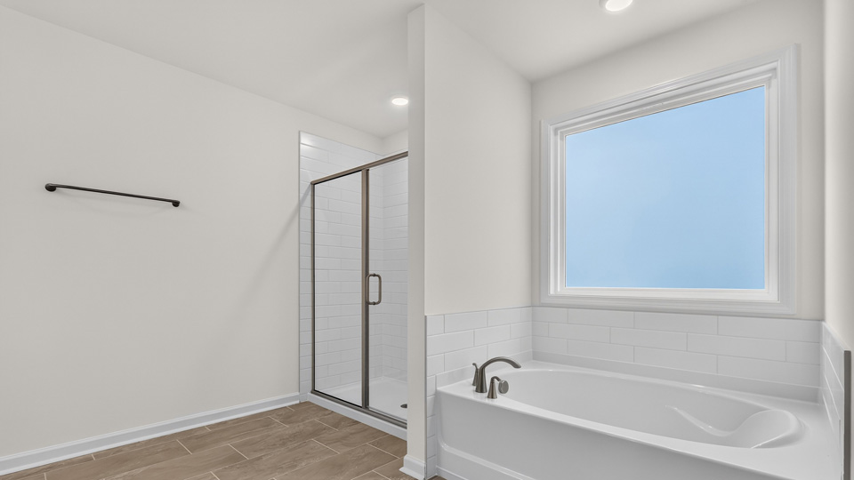 primary bathroom with separate tub and shower with walkin glass doors