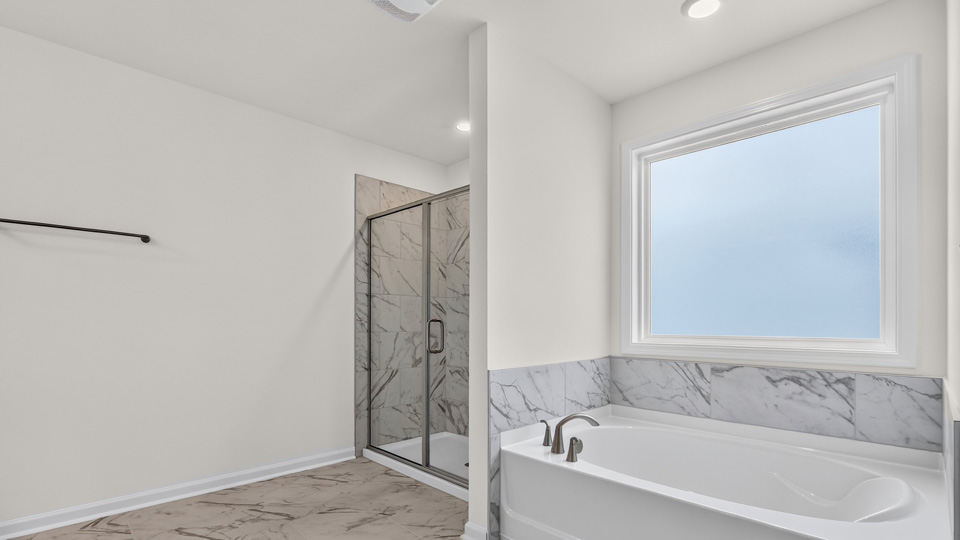 primary bathroom with separate tub and shower