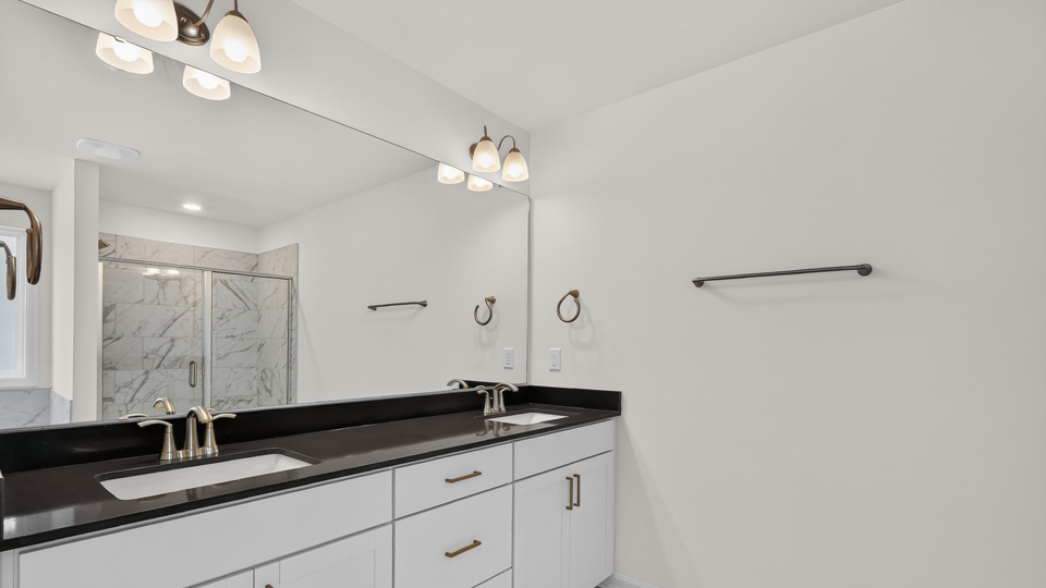 bathroom with white cabinets dual vanity and quartz countertops