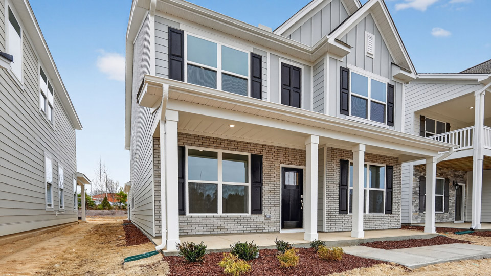 Two story home with white colored siding with a two car garage