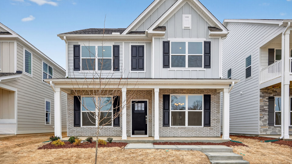 Two story home with white colored siding with a two car garage