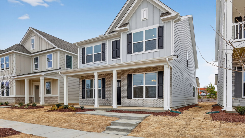 Two story home with white colored siding with a two car garage