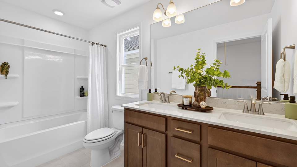 bathroom with brown cabinets and quartz countertops