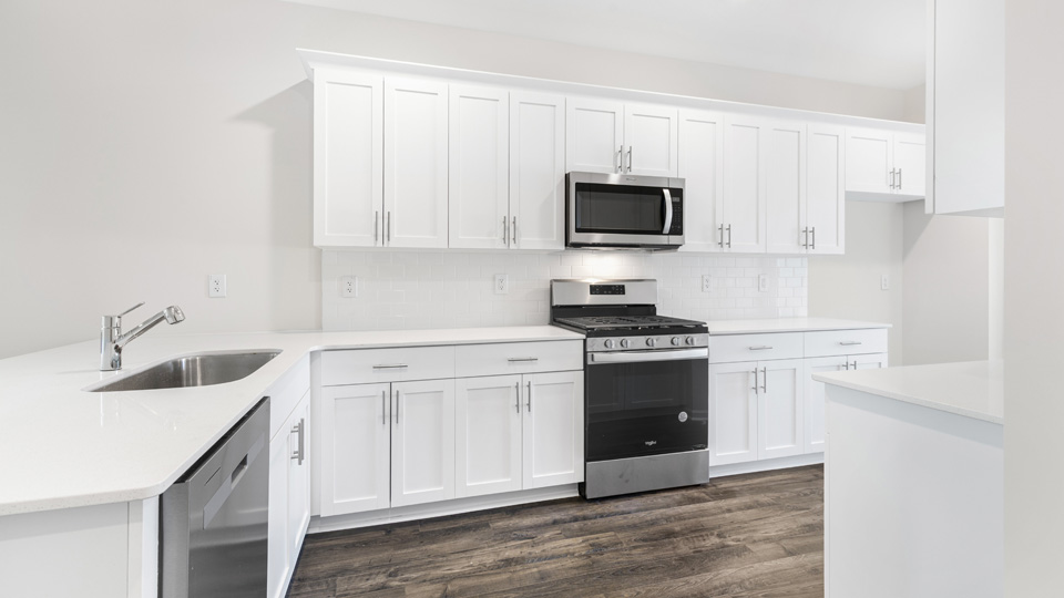 kitchen with quartz counters, kitchen island, pantry, stainless steel appliances