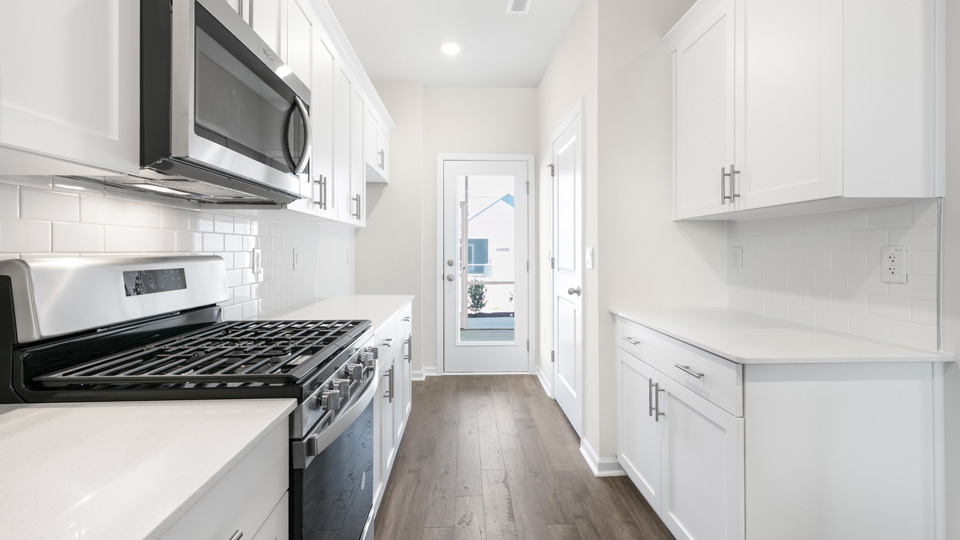 kitchen with quartz counters, kitchen island, pantry, stainless steel appliances