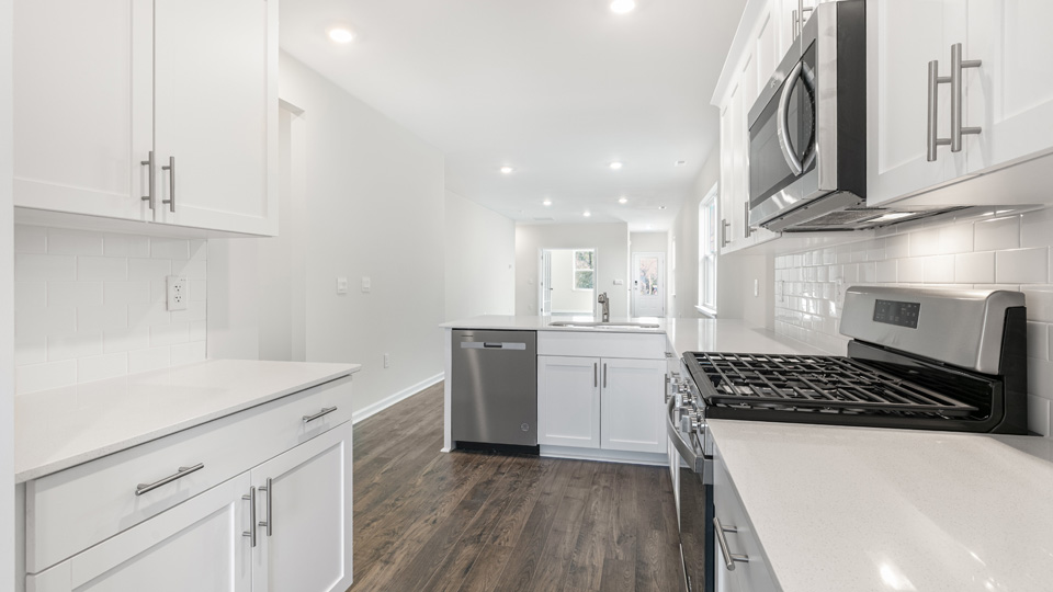 kitchen with quartz counters, kitchen island, pantry, stainless steel appliances