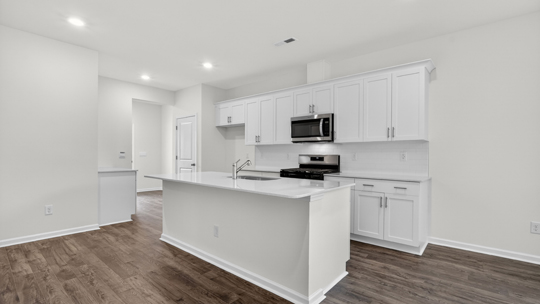 kitchen with white cabinets island and quartz countertops
