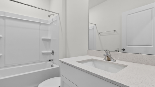 bathroom with quartz countertops and tub shower combo