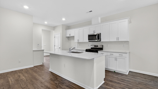 kitchen with white cabinets island and quartz countertops