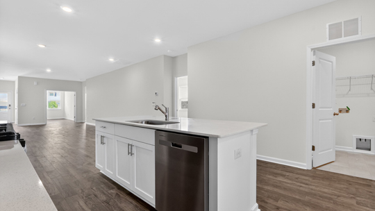 kitchen with white cabinets island and quartz countertops
