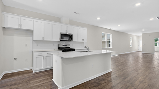kitchen with white cabinets island and quartz countertops