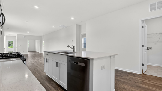 kitchen with quartz counters, kitchen island, pantry, stainless steel appliances