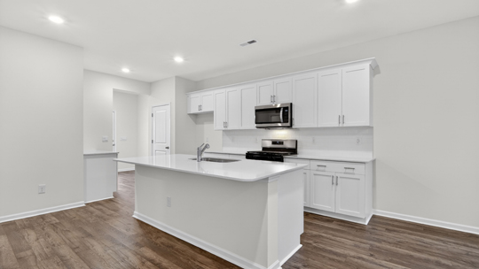 kitchen with large island white cabinets and quartz countertops