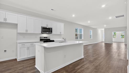 kitchen with large island white cabinets and quartz countertops