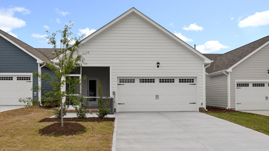 back of home and driveway and covered patio