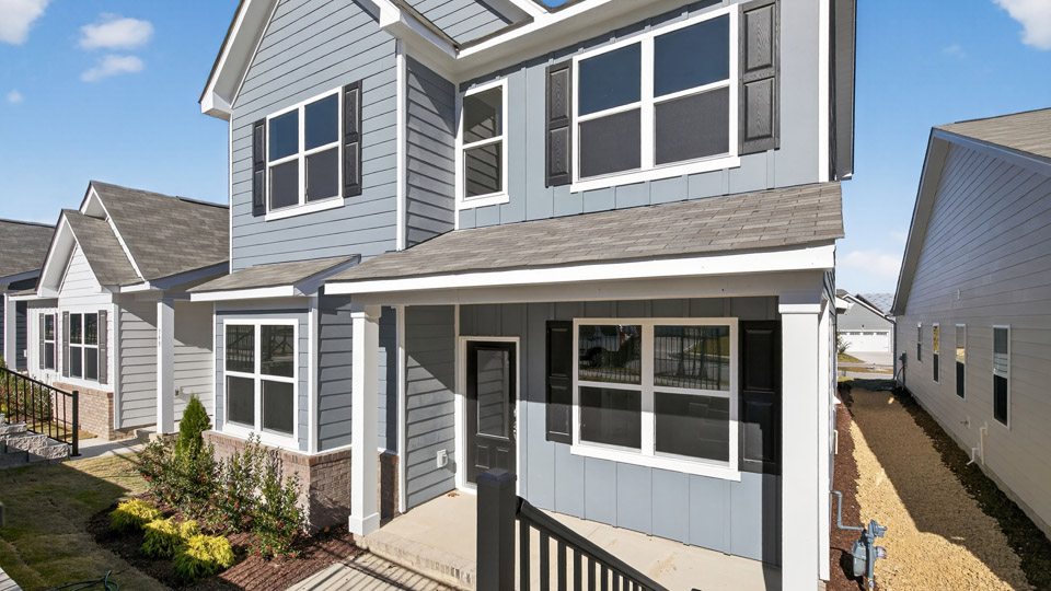 Two story home with blue colored siding and front porch