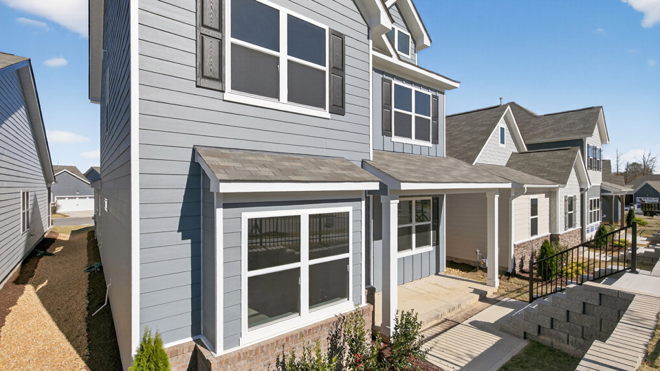 Two story home with blue siding and covered porch