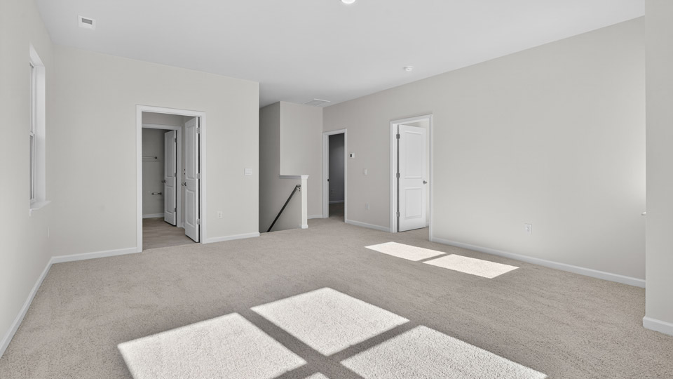 Upstairs loft area with carpet and windows