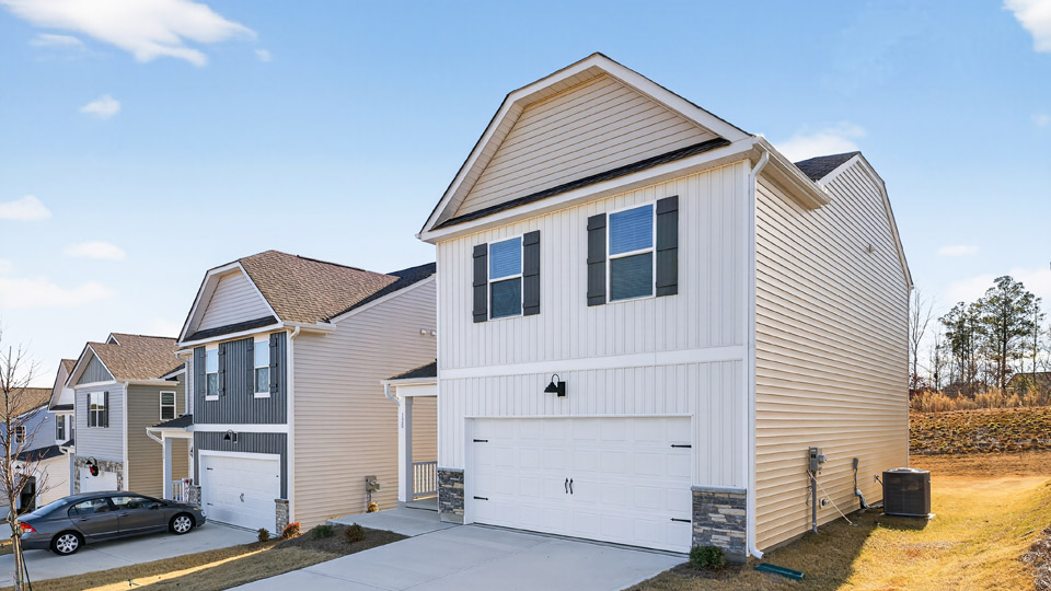 Two story home with white siding and two-car garage.