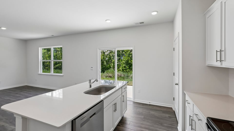 kitchen with quartz counters, kitchen island, pantry, stainless steel appliances