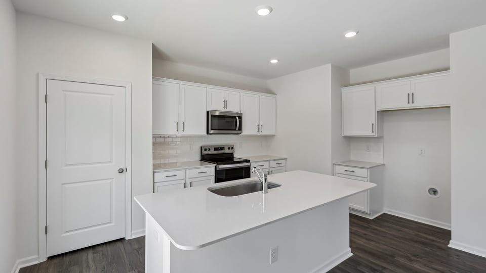 kitchen with quartz counters, kitchen island, pantry, stainless steel appliances