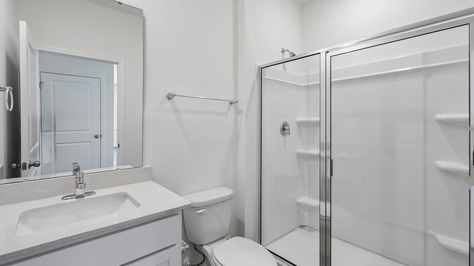 secondary bathroom with walk in shower and single vanity sink
