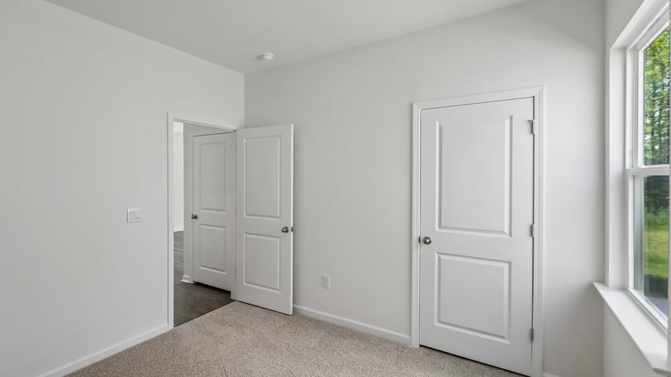 secondary bedroom with window and closet, carpeting