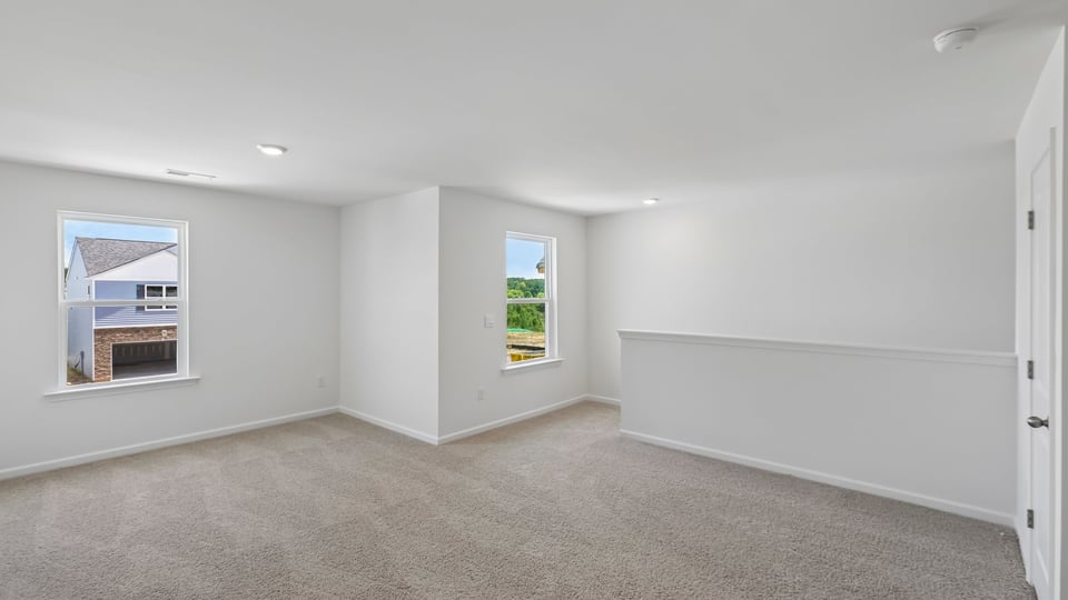 upstairs loft area with large windows and carpeting