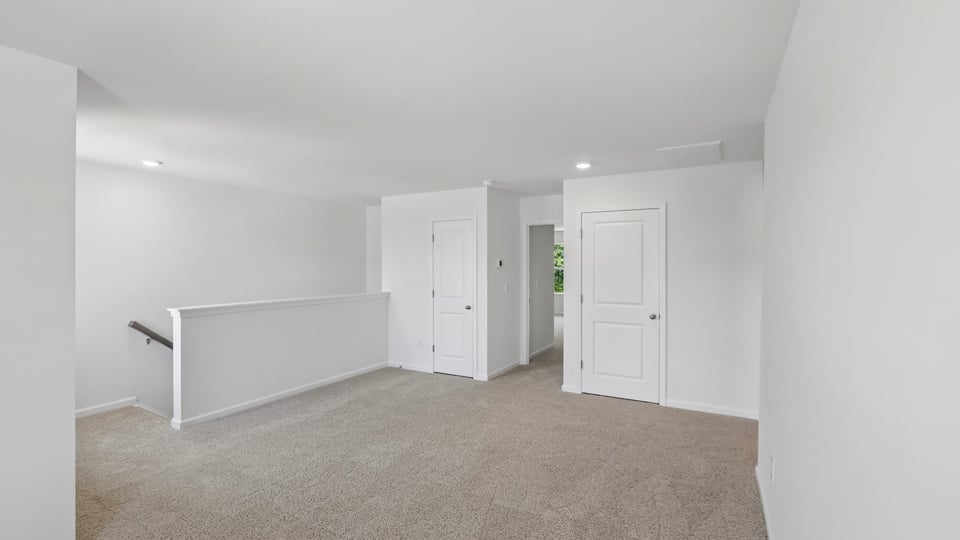 upstairs loft area with large windows and carpeting