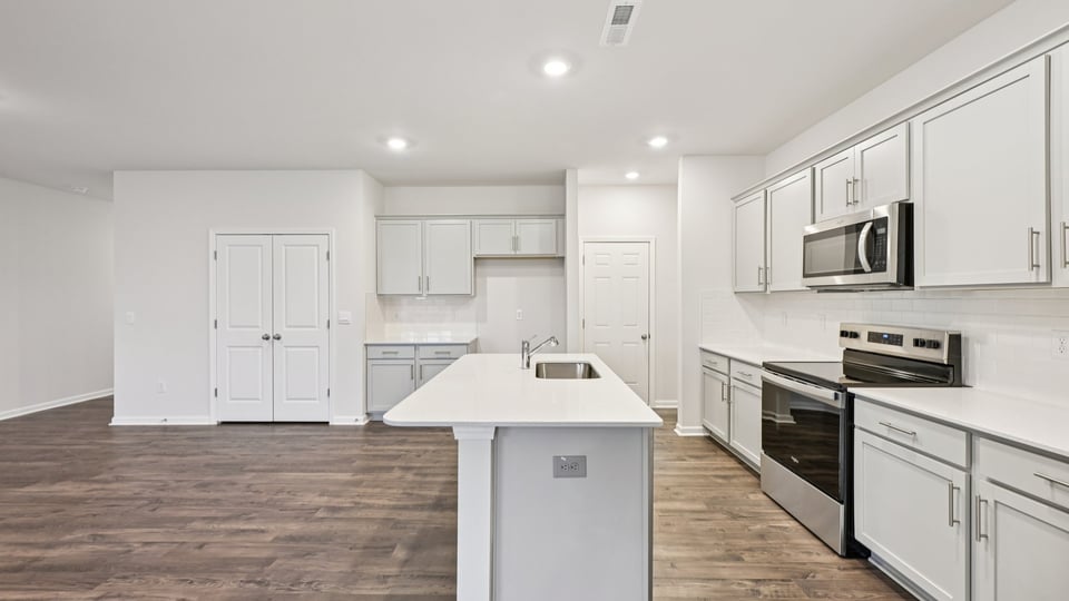 kitchen with white cabinets island and quartz countertops