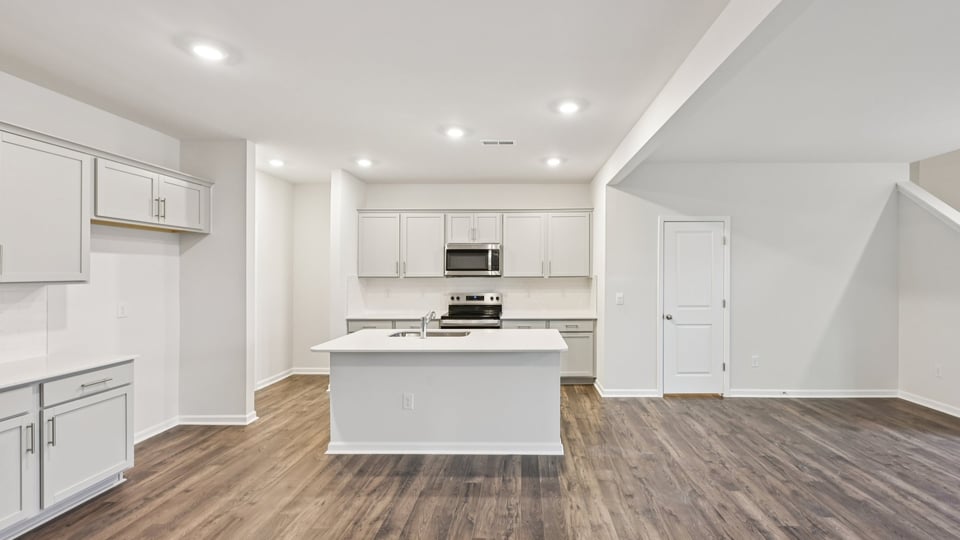 kitchen with white cabinets island and quartz countertops