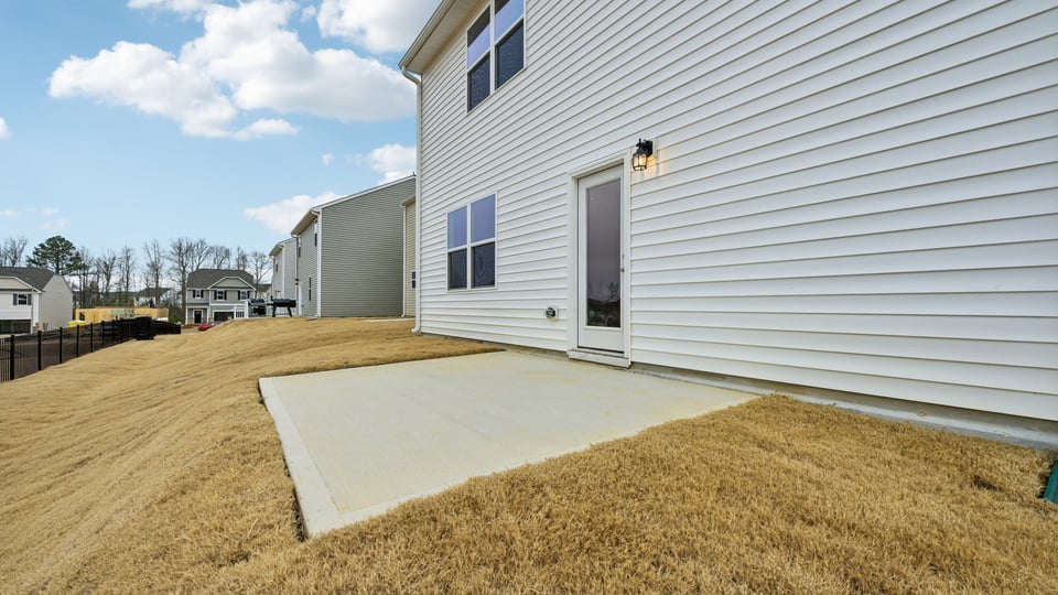 back of home with concrete patio