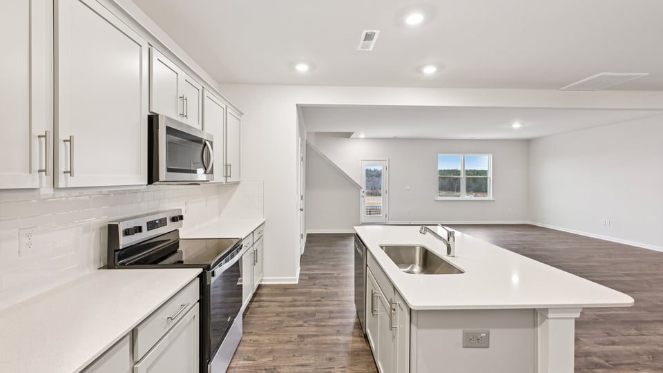 kitchen with quartz counters, kitchen island, pantry, stainless steel appliances