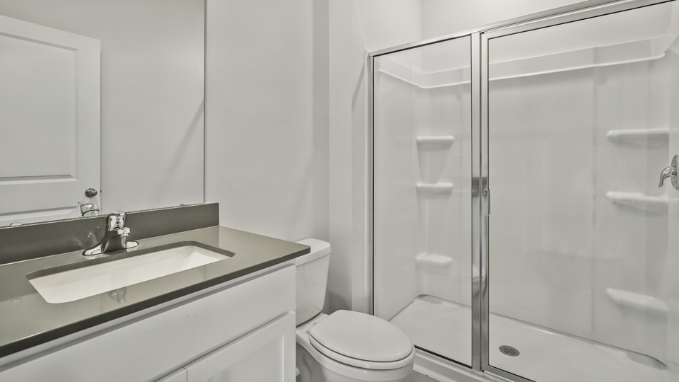 bathroom with quartz countertops and walkin shower