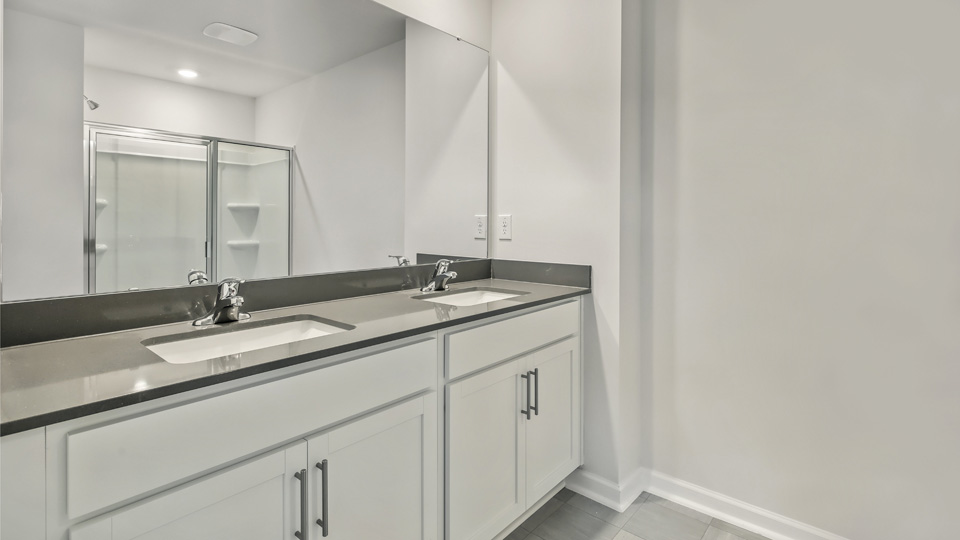 bathroom with dual vanity and quartz countertops