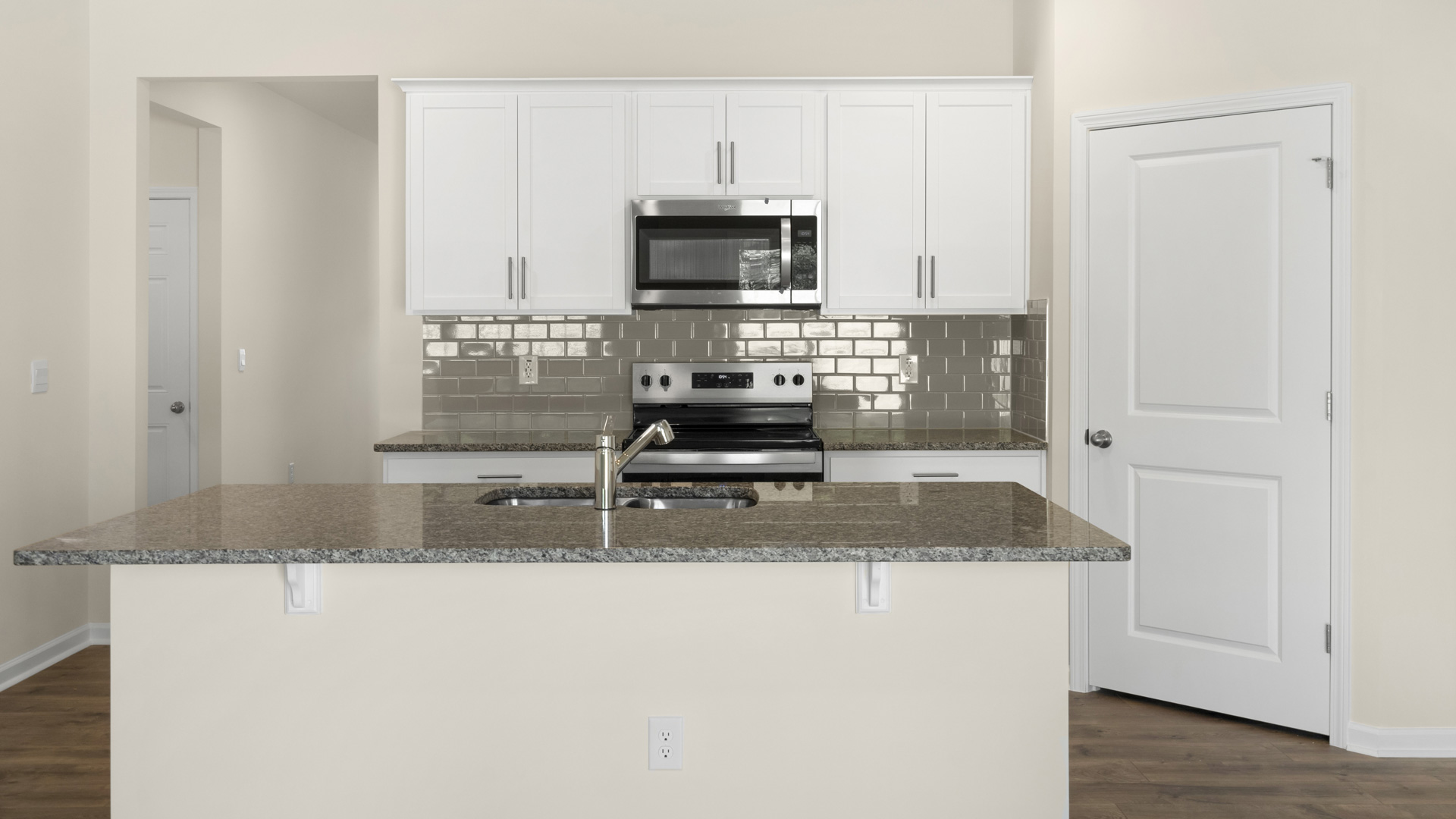 kitchen with quartz counters, kitchen island, pantry, stainless steel appliances