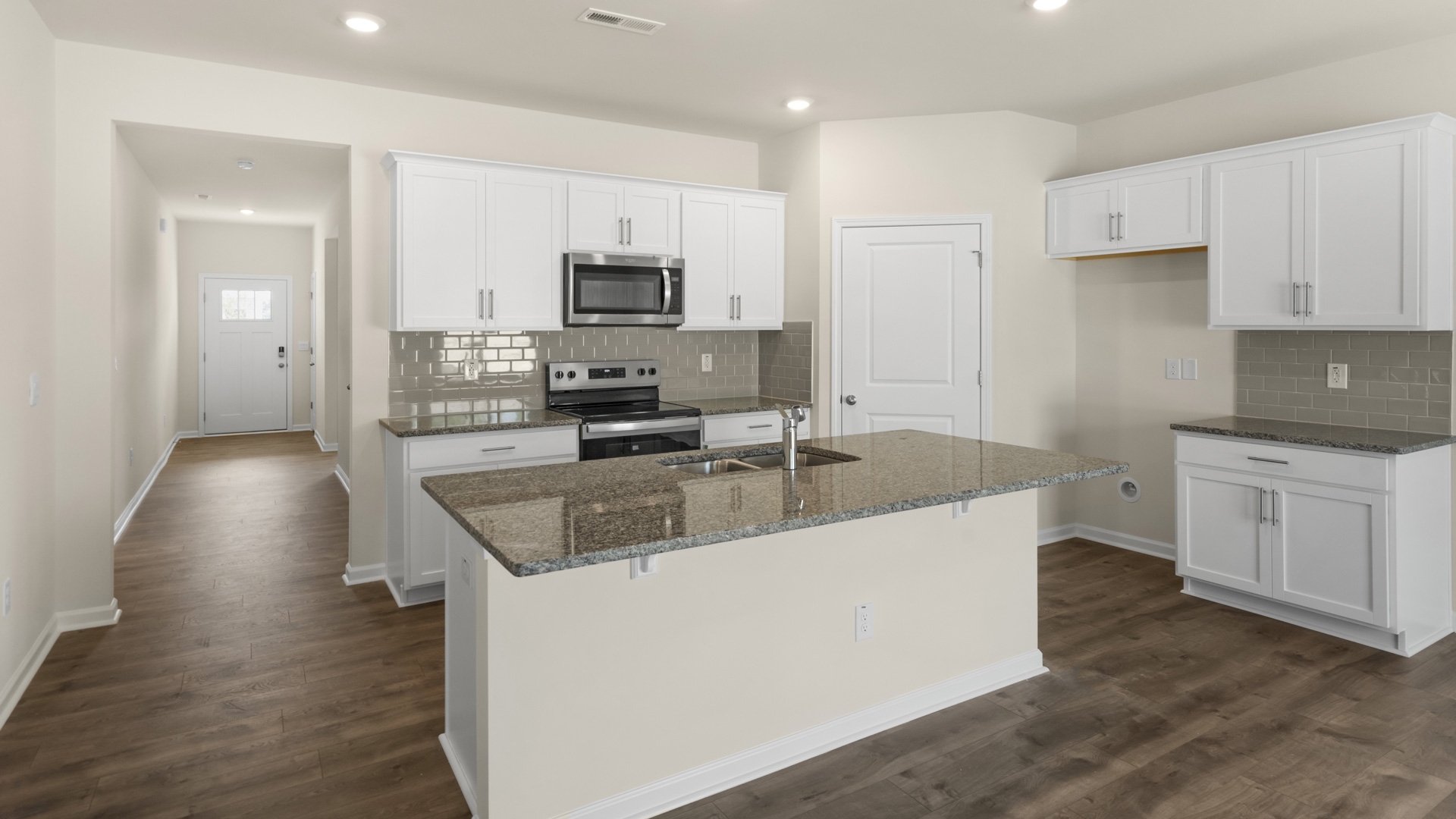kitchen with quartz counters, kitchen island, pantry, stainless steel appliances