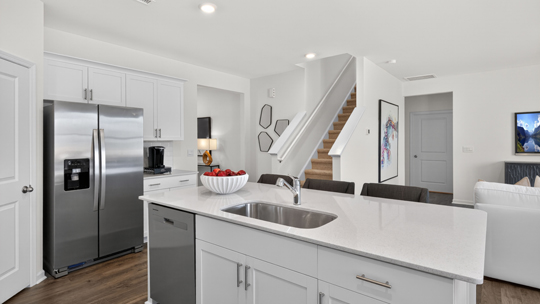 kitchen with quartz counters, kitchen island, pantry, stainless steel appliances