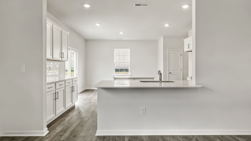 kitchen with quartz counters, kitchen island, pantry, stainless steel appliances