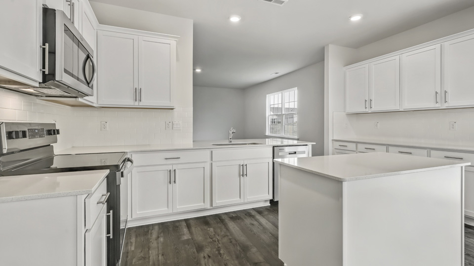 kitchen with quartz counters, kitchen island, pantry, stainless steel appliances