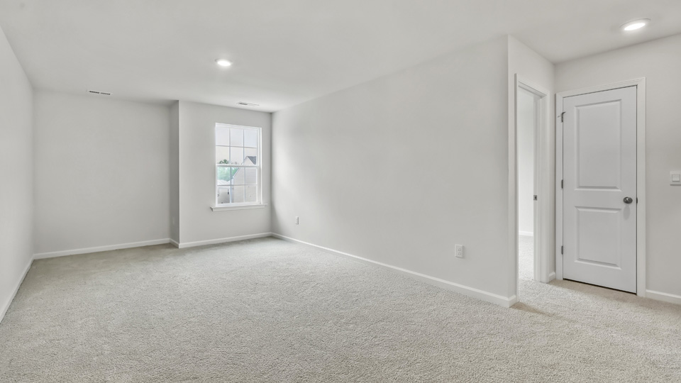 upstairs loft area with large windows and carpeting