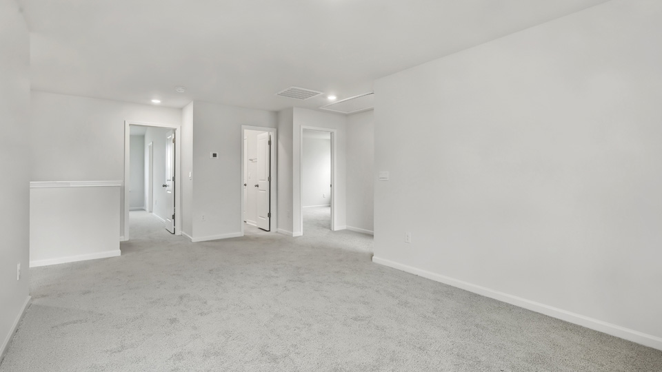 upstairs loft area with large windows and carpeting