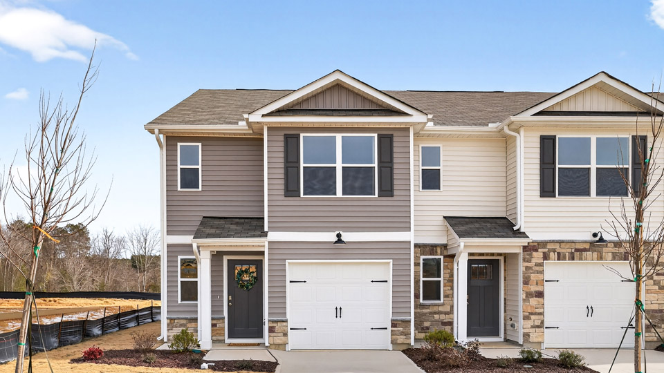 Two story town home with brown siding.